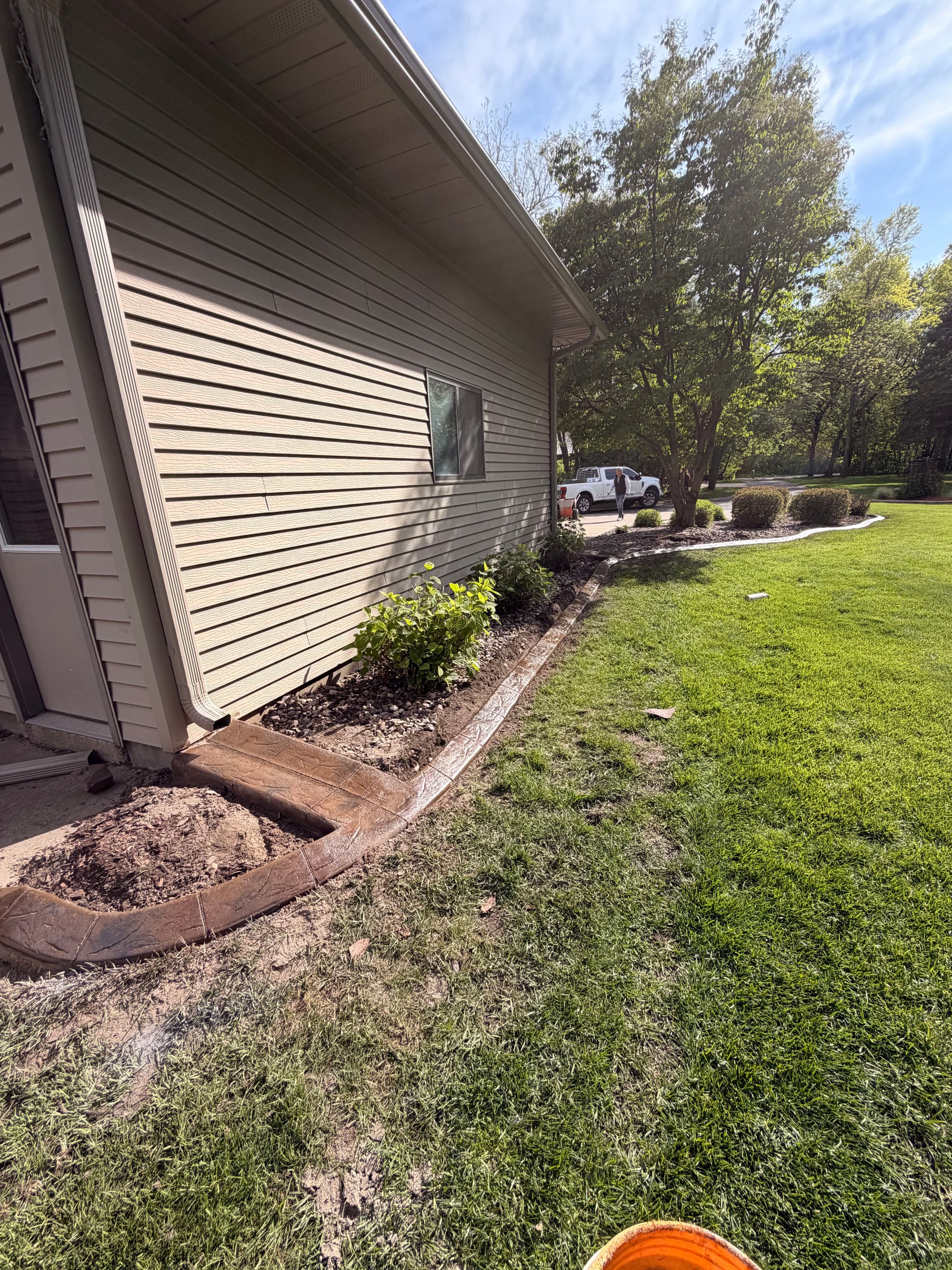 Stamped Concrete Curbing with Custom Downspout Pads Upgrades Curb Appeal image